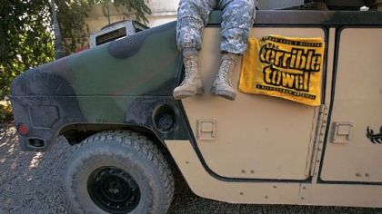 A member of the Pennsylvania National Guard sits on a Humvee draped with a Terrible Towel in January 2005 in Camp Habbaniyah, Iraq.