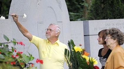 Steve Hapach, with his wife, Lorraine, far right, and daughter-in-law Barbara Hapach, places a flower on the memorial for Flight 427 at the Sewickley Cemetery during a service yesterday to remember the 132 people onboard the flight who perished 15 years ago. The Hapaches' son and Barbara Hapach's husband, Gary Hapach, was one of the passengers who died on Sept. 8, 1994.