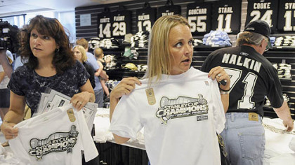 Monica Hanley, right, of Knoxville, Tenn., sizes up a Stanley Cup champions shirt yesterday at PenStation at Mellon Arena.