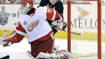 The Penguins' Evgeni Malkin slips the puck past Red Wings' goalie Chris Osgood in the first period at the Mellon Arena last night.
