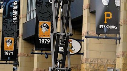 A stadium worker removes the Nate McLouth banner hanging outside PNC Park Thursday -- a day after the trade.