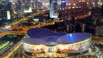 The Oriental Arts Center is an architectural marvel, with a flower-blossom shape when viewed from above and tall glass-panel walls seen from below.