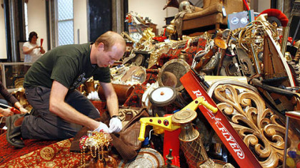 Seth Wait, with the Smithsonian Institution, checks that a replica of Fonzi's jacket is securely affixed to a display of "The Pile of Loot," a prop which was used in the movie  "Night At The Musem: Battle of The Smithsonian."