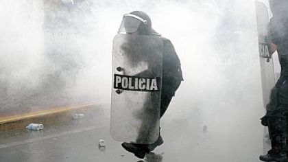 Surrounded by tear gas, police officers move forward during a protest against Venezuelan President Hugo Chavez in Caracas.
