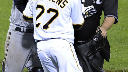 Home plate umpire Chad Fairfield gets between Pirates pitcher Jeff Karstens and Brewers catcher Jason Kendall.