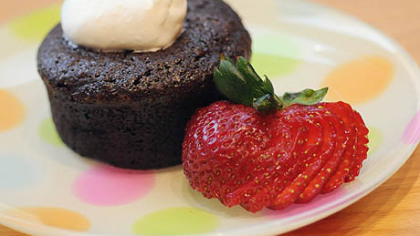 Pastry Chef Rachel Firestone's flourless chocolate cake topped with whipped cream and garnished with a strawberry.