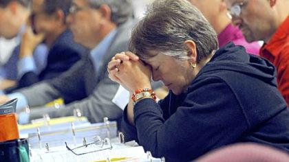 Voting member Janet Metcalfe, of Inver Grove Heights, Minn., pauses for a moment of prayer with other members of the Evangelical Lutheran Church in America yesterday after a tornado warning was announced at the Minneapolis Convention Center.