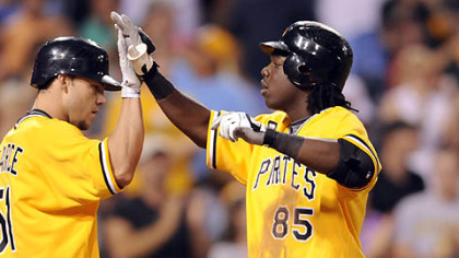 Pirates' Lastings Milledge is congratulated by teammate Steve Pearce after hitting a home run against the Reds in the fourth inning.