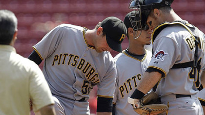 Pirates pitcher Zach Duke shows catcher Ryan Doumit  where he was hit by a ground ball on the ankle during yesterday's game.