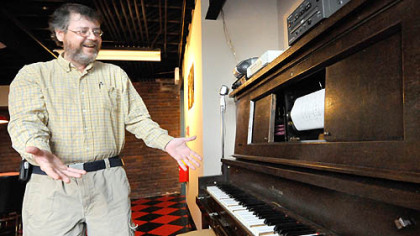 Johnstown Area Heritage Association curator Dan Ingram delights as the restored player piano starts to play in the Heritage Discovery Center.  He scoured dozens of auctions at closing clubs to get the items in the room.