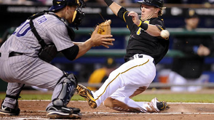 The Pirates' Nate McLouth slides safely into home plate against Rockies catcher Chris Iannetta in the sixth inning last night.