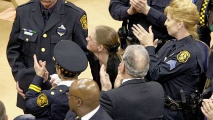 Officer Timothy McManaway, left, is honored during yesterday's memorial service. He was wounded in the hand while helping downed Officer Eric G. Kelly.
