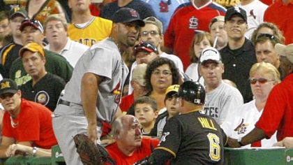 Pirates first base coach Perry Hill and Cardinals first baseman Albert Pujols attend to a fan down the first base line struck by a Garrett Jones foul ball in the seventh inning Friday night. Paramedics took the fan from the field.