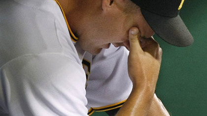 Pirates pitcher Steven Jackson sits in the corner of the dugout after giving up five runs, four of them earned, to the Diamondbacks in the 12th inning of last night's 11-6 loss at PNC Park.
