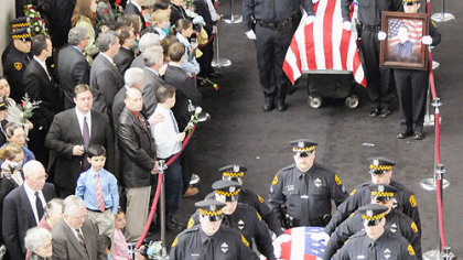 Pittsburgh Police pallbearers carry the caskets of slain officers, from front, Stephen J. Mayhle, Paul J. Sciullo II and Eric G. Kelly past their families at the City-County Building to waiting hearses yesterday.