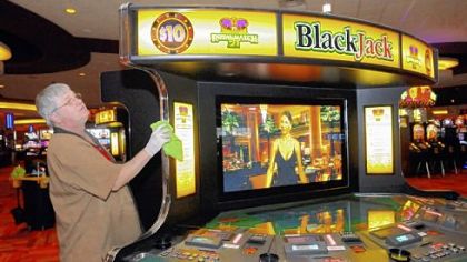 Meadows Casino worker Ron Wise does last-minute polishing on a video blackjack machine.