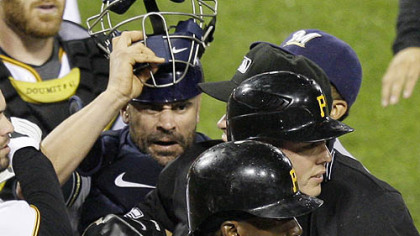 Pirates pitcher Jeff Karstens, partially blocked facing right, is helped out of an altercation with Brewers catcher Jason Kendall, by teammate Andre McCutchen (22) during the eighth inning.
