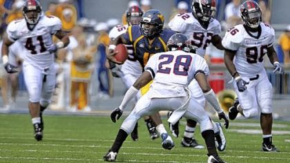West Virginia's Jarrett Brown avoids Liberty defenders yesterday at Mountaineer Field in Morgantown, W.Va.