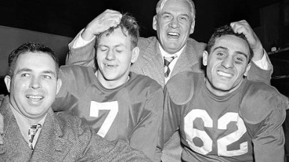 Coach Jimmy Conzelman musses the hair of Charley Trippi, right, and Elmer Angsman after the 1947 title game.