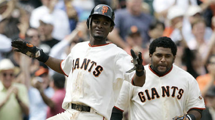 Giants second baseman Eugenio Velez, left, celebrates at home plate after scoring the Giants' only run in the 10th inning. At right is Giants catcher Pablo Sandoval. Velez scored from second base after outfielder Randy Winn lined an RBI single down the first base line.