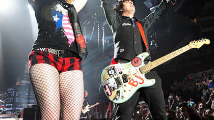 Brit Stiles, left, a radio contest winner, is pulled up on stage by Green Day's Billie Joe Armstrong during   "21st Century Breakdown" as the opening song at Mellon Arena last night.