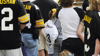 Laura Souider and her nephew Matthew Scardina, 3, from Towanda, Pa., rest up while waiting in line to kick a field goal during the Steelers' 2009 Fan Blitz at Heinz Field yesterday.