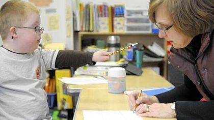 Special-education teacher Beth Sieg's student Charlie Osborn indicates his preference for her to draw an animal first as she works with him in her class at St. Angela Merici School in White Oak.