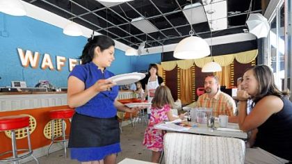 Waitress Zena Ruiz serves up waffles to the Peterson family of West Mifflin, who stopped for breakfast on their way to the zoo.
