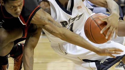 Gilbert Brown snags a loose ball from Cincinnati's Alvin Mitchell yesterday.