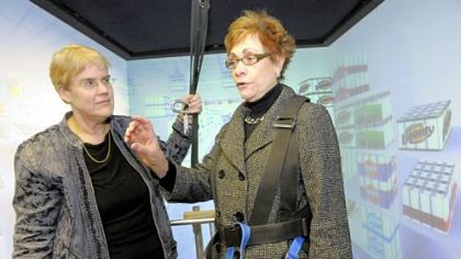 Paula Calabrese, right, tells Sue Whitney about the sensations she experiences as strolls the virtual grocery store.