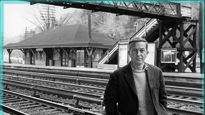 John Cheever stands at the kind of commuter station often found in his fiction.