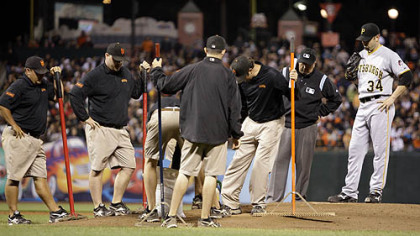Pirates pitcher John Grabow waits as groundskeepers add more dirt to the pitching mound during the eighth inning.