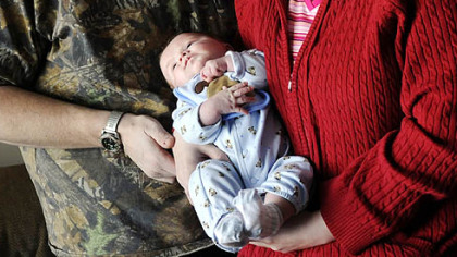 Phillip and Melody McIntyre hold baby Trent in their New Middlesex apartment.