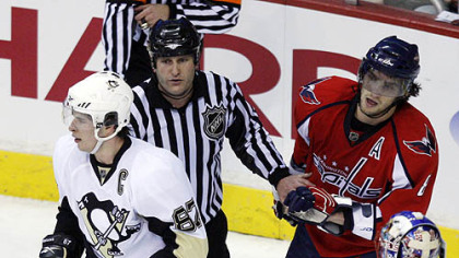 An official separates Sidney Crosby and Alex Ovechkin yesterday.