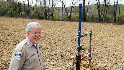 William Wasser, Maurice K. Goddard State Park manager, at the Hill No. 1 well head, which is just off the bike trail along the shores of Lake Wilhelm. By summer, the well will be nearly invisible in the middle of a cornfield.