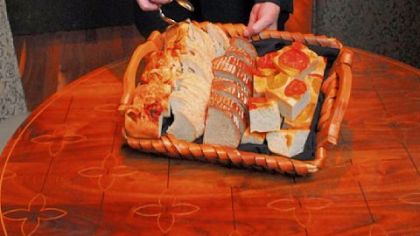 Manager Ron Ausnehmer holds one of the baskets of a selection of breads at the Eleven Contemporary Kitchen in the Strip District.
