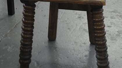 This carved oak grotesque face chair made in the late 19th or early 20th century features a decorated back with a man's face wearing a cap, painted eyes, cut-out mouth, plank seat with molded rim and spool turned legs. These chairs are often found in Pittsburgh homes and this one is estimated to sell for between $150 and $250.