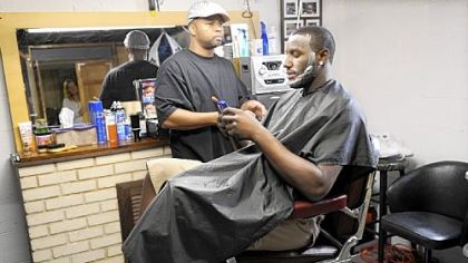 DeJuan Blair keeps up with his text messages as he gets a haircut by his friend Greg Mitchell in Monroeville yesterday. Blair slipped to the second round of the NBA draft and was chosen by the San Antonio Spurs.