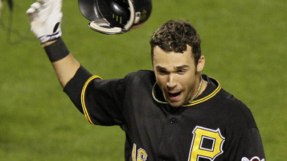 Pirates outfielder Garrett Jones throws off his batting helmet as he touches home plate after hitting a walk-off 14th-inning solo home run off Giants pitcher Bob Howry.