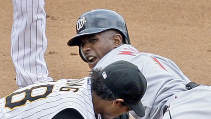 Second baseman Delwyn Young, left, keeps the tag on the Nationals' Nyjer Morgan to get the out on a stolen base attempt during the sixth inning this afternoon.