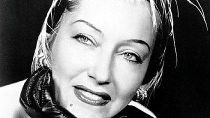 Actress Gloria Swanson wearing her two rock crystal, diamond and platinum bracelets made in 1930.