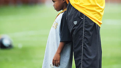 Mason Tomlin joins coach Dad before the start of yesterday's afternoon practice at Saint Vincent College.