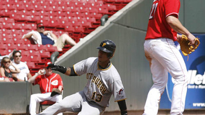 Pirates shortstop Ronny Cedeno slides into third base for a triple past Reds third baseman Scott Rolen in the seventh inning of the first game.
