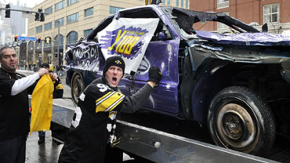 Steeler fan Denny Rager of Johnstown, adds his dents to  the "Baltimoron" car Jason Watkins drove around town, including near Heinz Field before the AFC Championship game. The car was part of a charity radio event Saturday.