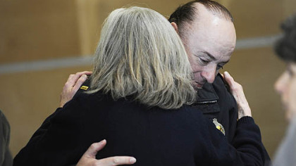 Lt. Michael Scott receives a hug from Beth Pittinger, director of the Citizen Police Review Board, after a news conference yesterday afternoon about the officers' shooting.