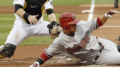 Diamondbacks outfielder Garardo Parra slides past Pirates catcher Ryan Doumit trying to score from first base on a double by third baseman Mark Reynolds in the third inning. No call was made on the play, but Parra was called out after Doumit later tagged him.
