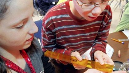 Despite an early setback, the silkworm project is proceeding in Dana Fenio's fifth-grade class at Mars Centennial Elementary School. Jimmy Pierre, right, measures Kelly O'Connell's zebra silkworm before she puts it into one of the student-made nests.