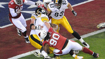 Ben Roethlisberger is stopped short of the goal by Cardinals' Calais Campbell, left, and Darnell Dockett, bottom, in the first quarter tonight at Super Bowl XLIII.