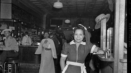Portrait of waitress at Crawford Grill No. 1, with Hughey Smith seated on bar stool on
left, c. 1946-1947.