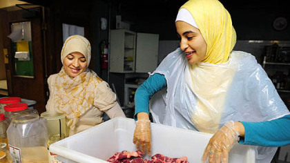 Asma Houbaizhi, left, watches Amina Lagnaovi prepare lamb for Ramadan at the Islamic Center of Pittsburgh in Oakland yesterday.